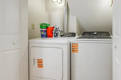 a small kitchen with a stove and a washer and dryer at Honey Paws Inn Wilmington Home 6 Mi to Mount Snow in Wilmington