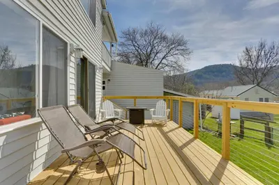a wooden deck with two chairs on a house at Scenic Home on the Delaware River, Pet-Friendly! in Starlight