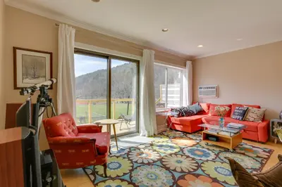 a living room with red furniture and a large window at Scenic Home on the Delaware River, Pet-Friendly! in Starlight