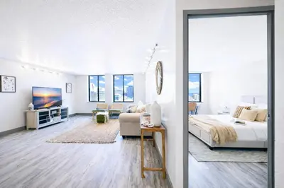 a white bedroom with a bed and a tv at The Hartford Skyline - Stylish Downtown Condo with Wifi Gym in Hartford