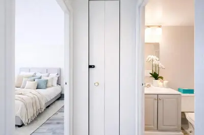 a white bedroom with a bed and a sink at The Hartford Skyline - Stylish Downtown Condo with Wifi Gym in Hartford