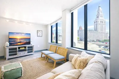 a living room with a couch and a large window at The Hartford Skyline - Stylish Downtown Condo with Wifi Gym in Hartford