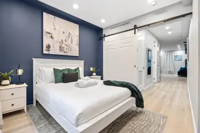 a bedroom with a white bed and blue walls at SWJ G - Save on 2Day or more Stays 25min to Times Sq in New York