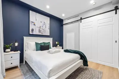 a bedroom with a white bed and blue walls at SWJ G - Save on 2Day or more Stays 25min to Times Sq in New York