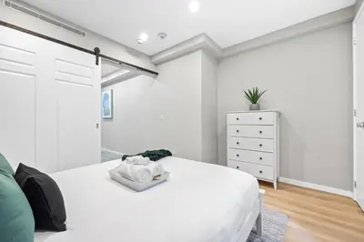 a white bedroom with a bed and a dresser at SWJ G - Save on 2Day or more Stays 25min to Times Sq in New York