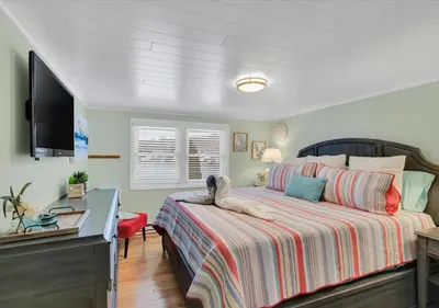a bedroom with a bed and a flat screen tv at Sunset Cove in East Hampton