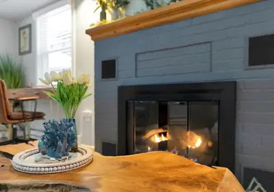 a living room with a fireplace and a wooden table at Sunset Cove in East Hampton
