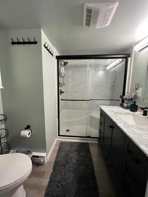 a bathroom with a shower and a toilet and a sink at Sunset Cove in East Hampton