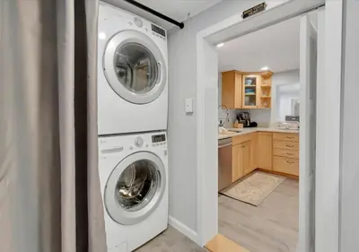 a laundry room with a washer and dryer next to a kitchen at Sunset Cove in East Hampton