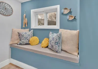 a row of pillows sitting on a bench in a room at Sunset Cove in East Hampton