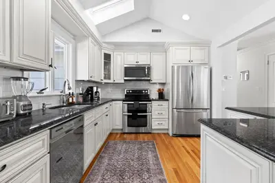a kitchen with white cabinets and stainless steel appliances at New Beach Home near Stamford Downtown/Shippan in Stamford