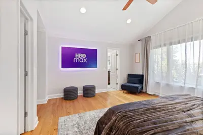 a bedroom with a bed and a tv on the wall at New Beach Home near Stamford Downtown/Shippan in Stamford