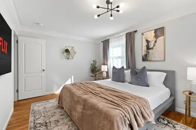 a white bedroom with a large bed and a window at New Beach Home near Stamford Downtown/Shippan in Stamford