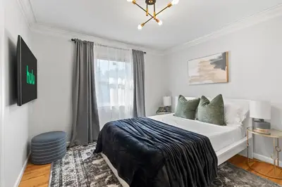a white bedroom with a bed and a window at New Beach Home near Stamford Downtown/Shippan in Stamford