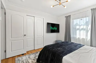 a white bedroom with a bed and a window at New Beach Home near Stamford Downtown/Shippan in Stamford