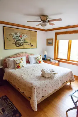 a bedroom with a large bed and a ceiling fan at Honey Maple Grove BnB in Bedford