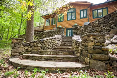 a stone stairway leading to a house with a stone wall at Honey Maple Grove BnB in Bedford
