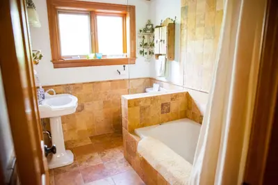 a bathroom with a tub and a sink and a toilet at Honey Maple Grove BnB in Bedford