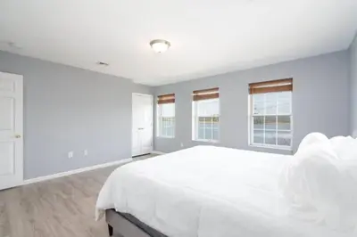 a white bedroom with a large bed and windows at Gorgeous Waterfront 3 Bedroom, 1.5 Bathroom Unit. in New Haven