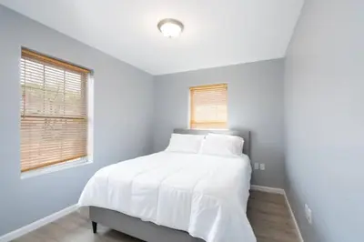 a bedroom with a bed with white sheets and a window at Gorgeous Waterfront 3 Bedroom, 1.5 Bathroom Unit. in New Haven