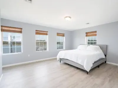 a white bedroom with a large bed and windows at Gorgeous Waterfront 3 Bedroom, 1.5 Bathroom Unit. in New Haven
