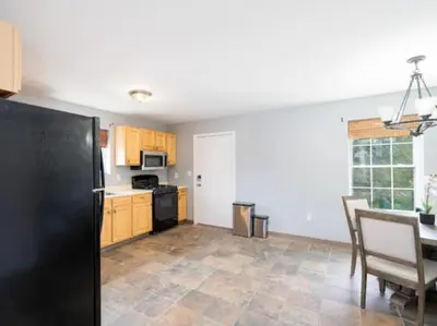 a kitchen with a table and a black refrigerator at Gorgeous Waterfront 2:1 - 2 houses in 1 building. in New Haven