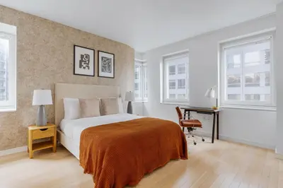 a bedroom with a bed and a desk and windows at Midtown 1br w doorman gym wd nr Rock Center NYC-1127 in New York