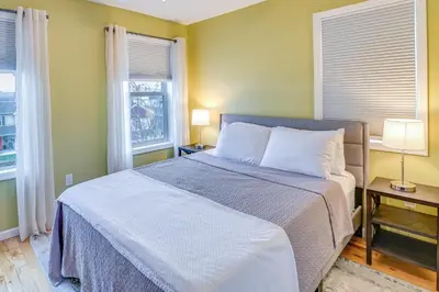 a bed in a room with two windows and a bed sidx sidx sidx at Saratoga Springs Vacation Rental with Lake Views! in Saratoga Springs