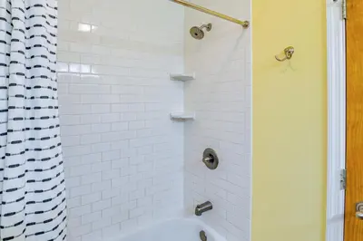 a white tiled shower with a shower curtain at Saratoga Springs Vacation Rental with Lake Views! in Saratoga Springs