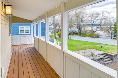 a porch of a blue house with a large window at Saratoga Springs Vacation Rental with Lake Views! in Saratoga Springs
