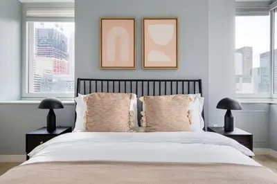 a bedroom with a bed with two pictures on the wall at Midtown 1br w doorman gym wd nr Rock Center NYC-1131 in New York