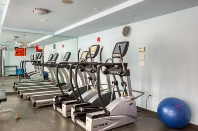 a row of exercise bikes lined up in a gym at Midtown 1br w doorman gym wd nr Rock Center NYC-1131 in New York