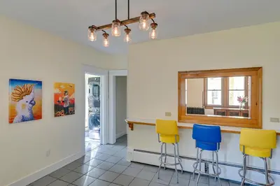 a kitchen with yellow and blue bar stools at Spacious Historic Home in the Berkshires! in Pittsfield