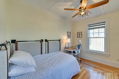 a bedroom with a bed with a ceiling fan and a desk at Spacious Historic Home in the Berkshires! in Pittsfield