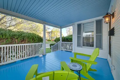 a porch with green chairs and a table at Spacious Historic Home in the Berkshires! in Pittsfield
