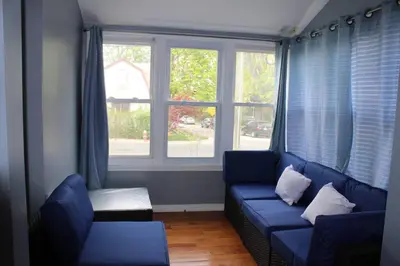 a living room with a blue couch and a window at Beautiful place minutes away to New York City . in Teaneck