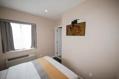a bedroom with a bed and a window at Flushing Garden Hotel in Queens