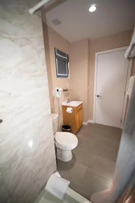 a bathroom with a toilet and a sink at Flushing Garden Hotel in Queens
