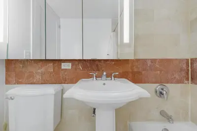 a bathroom with a sink and a toilet and a mirror at Global Luxury Suites at The Marc in New York