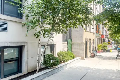 a building on a city street with a tree at Midtown E Studio w Great light Gym NYC-139 in New York