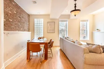 a living room with a table and a couch at The Brick House at Yale New Haven ( Wooster Square) in New Haven