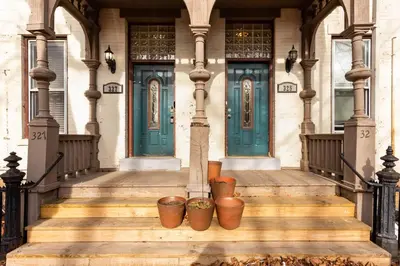 a house with blue doors and pots on the stairs at The Brick House at Yale New Haven ( Wooster Square) in New Haven