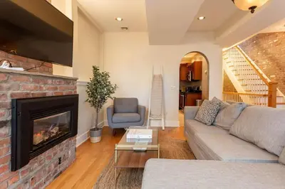 a living room with a couch and a fireplace at The Brick House at Yale New Haven ( Wooster Square) in New Haven