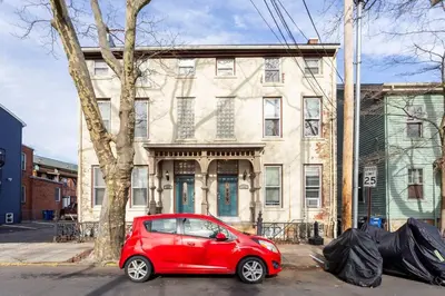 a small red car parked in front of a building at The Matisse at Wooster Square Yale With Parking in New Haven