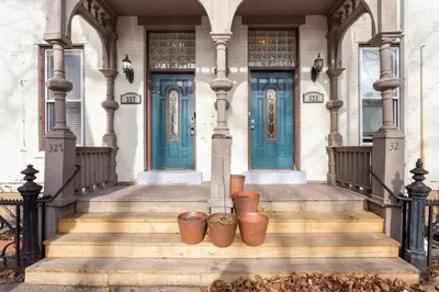 a house with blue doors and some pots on the stairs at The Matisse at Wooster Square Yale With Parking in New Haven