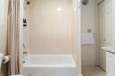 a white bathroom with a tub and a shower at The Matisse at Wooster Square Yale With Parking in New Haven