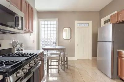 a kitchen with a stainless steel refrigerator and a table at The Matisse at Wooster Square Yale With Parking in New Haven