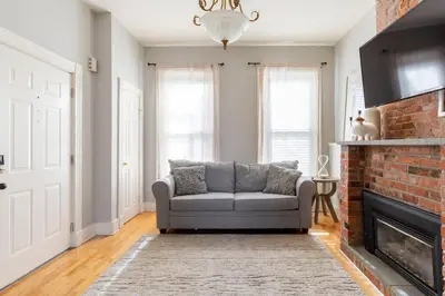 a living room with a couch and a fireplace at The Matisse at Wooster Square Yale With Parking in New Haven